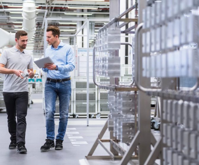 Two man walking in a factory