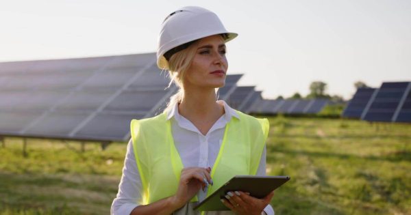 Women with a tablet in front of solar panels